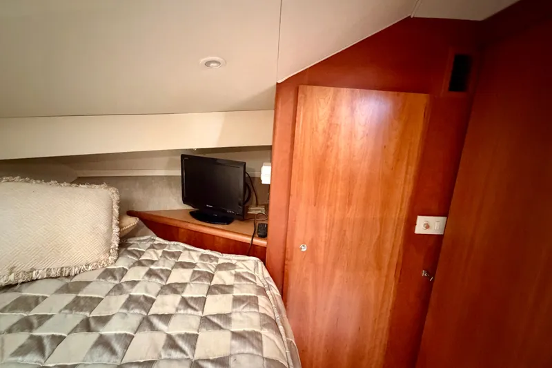 Slide: The Image of Cozy cabin interior of 2002 Silverton 330 Sport Bridge with TV and wooden accents. - 34