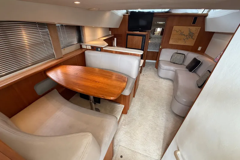 Slide: The Image of 2002 Silverton 330 Sport Bridge interior with dining area, plush seating, and modern amenities. - 22
