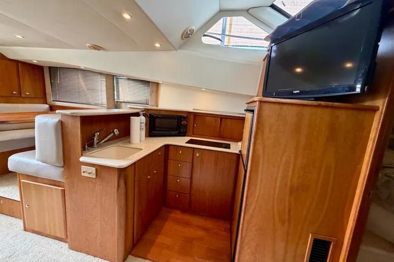 Slide: The Image of Interior of 2002 Silverton 330 Sport Bridge yacht with kitchenette and TV. - 28