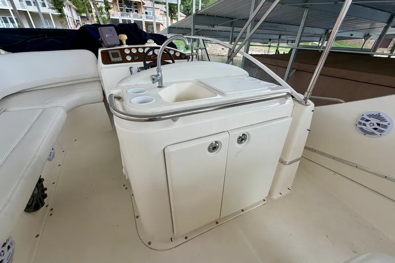 Slide: The Image of 2002 Silverton 330 Sport Bridge boat interior with sink and seating area. - 12