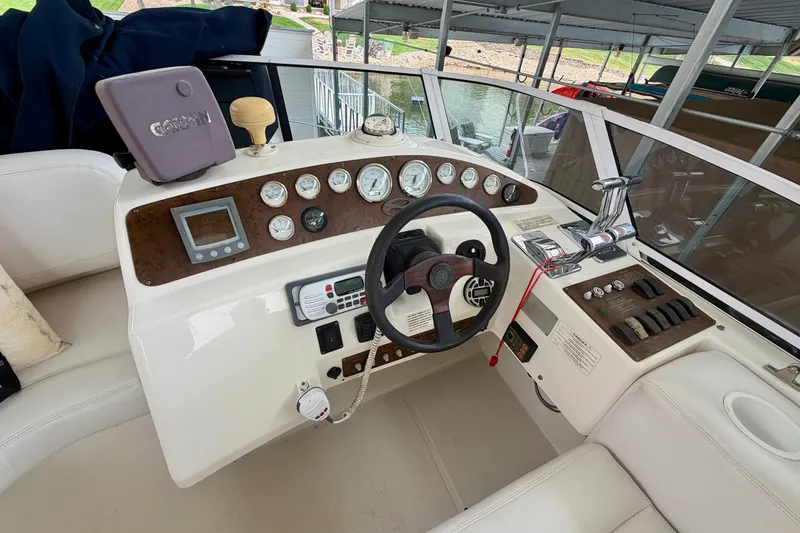 Slide: The Image of 2002 Silverton 330 Sport Bridge helm with gauges, steering wheel, and control panel. - 15