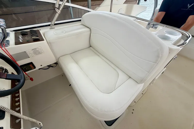 Slide: The Image of 2002 Silverton 330 Sport Bridge helm with white seating and control panel. - 16