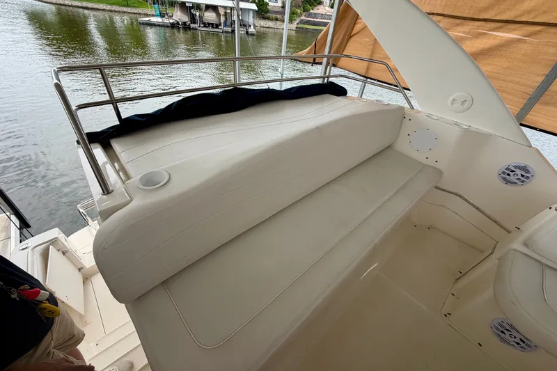 Slide: The Image of 2002 Silverton 330 Sport Bridge boat interior with white seating and water view. - 13