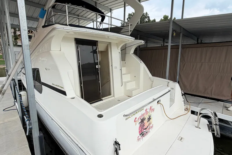 Slide: The Image of 2002 Silverton 330 Sport Bridge yacht docked under a covered marina. - 8