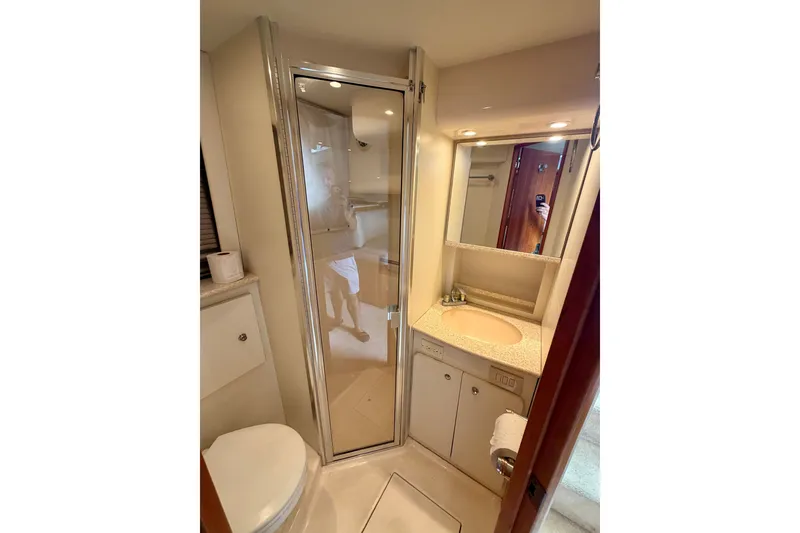 Slide: The Image of Bathroom interior of 2002 Silverton 330 Sport Bridge yacht, featuring shower and vanity. - 32
