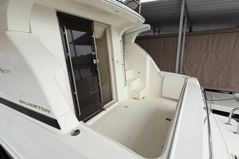 Slide: The Image of 2002 Silverton 330 Sport Bridge yacht, featuring a spacious deck and sleek design. - 9