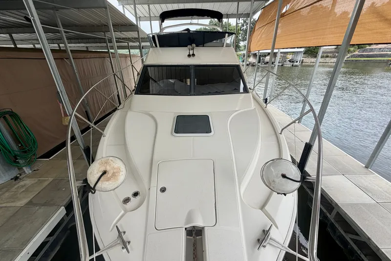 Slide: The Image of 2002 Silverton 330 Sport Bridge docked in a covered marina, showcasing sleek design. - 5