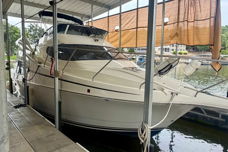 Slide: The Image of 2002 Silverton 330 Sport Bridge yacht docked under a covered marina. - 1