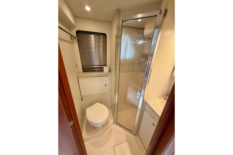 Slide: The Image of Bathroom interior of 2002 Silverton 330 Sport Bridge yacht, featuring shower and toilet. - 31