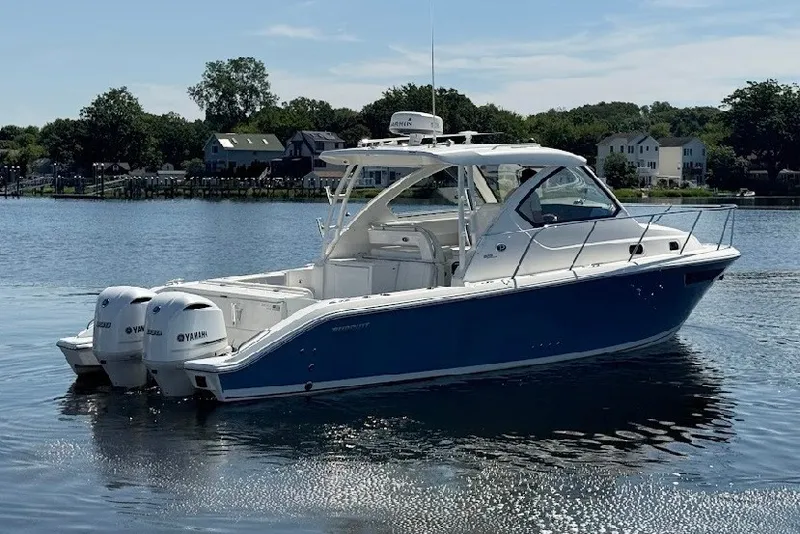 Slide: The Image of 2021 Pursuit OS 325 Offshore boat with twin Yamaha engines on a calm lake. - 1