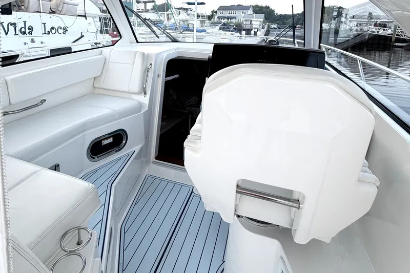 Slide: The Image of 2021 Pursuit OS 325 Offshore boat interior with white seating and modern helm. - 11