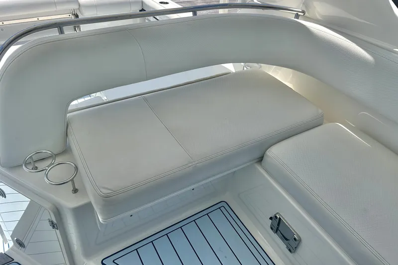 Slide: The Image of 2021 Pursuit OS 325 Offshore boat interior with white cushioned seating and cup holders. - 12