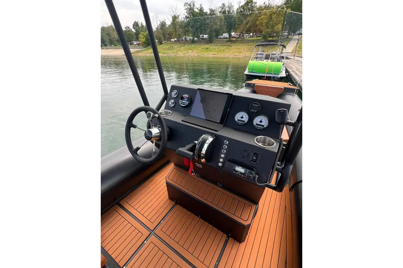 Slide: The Image of 2026 Patrol 760 RIB boat dashboard with modern controls and wooden flooring. - 10