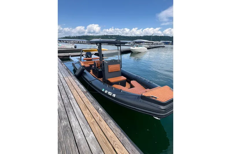 Slide: The Image of 2026 Patrol 760 RIB boat docked at a marina under a clear blue sky. - 24