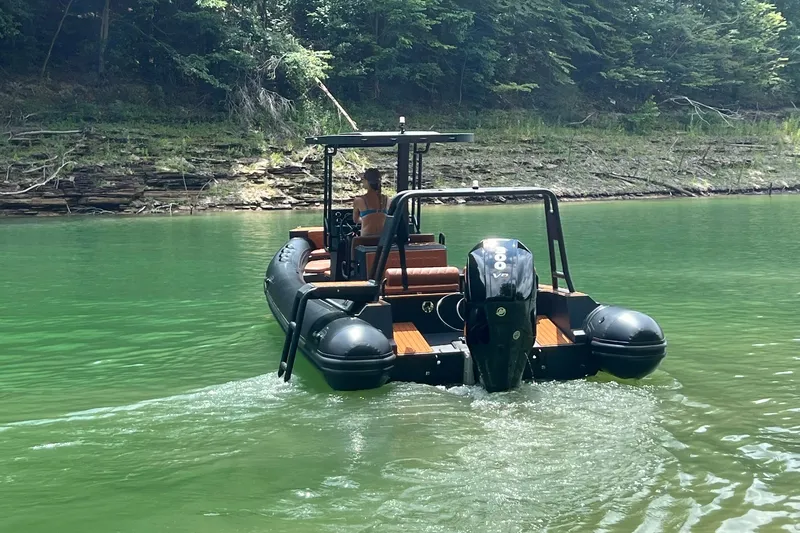 Slide: The Image of 2026 Patrol 760 RIB navigating a serene green river with lush forest backdrop. - 5