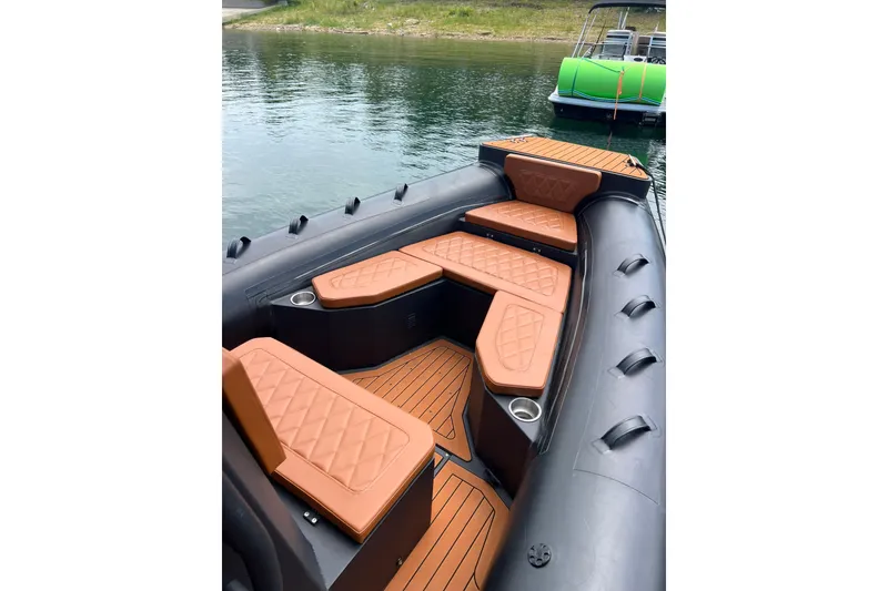 Slide: The Image of 2026 Patrol 760 RIB boat with brown cushioned seating on calm water. - 12