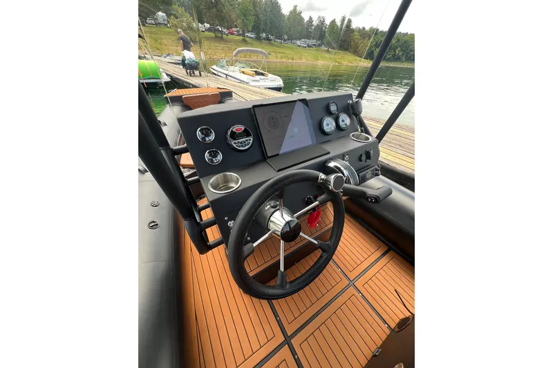 Slide: The Image of Steering console of 2026 Patrol 760 RIB boat with modern controls and wooden flooring. - 11