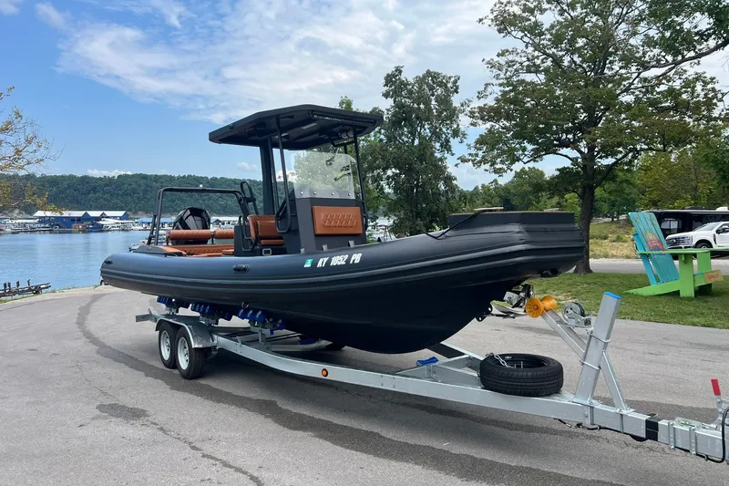 Slide: The Image of 2026 Patrol 760 RIB boat on trailer by a scenic lakeside. - 20