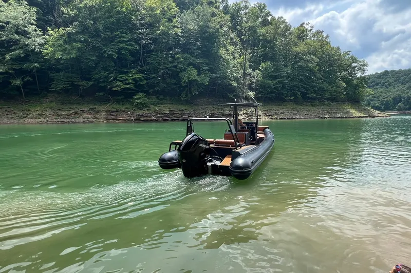 Slide: The Image of 2026 Patrol 760 RIB boat cruising on a serene lake surrounded by lush greenery. - 6