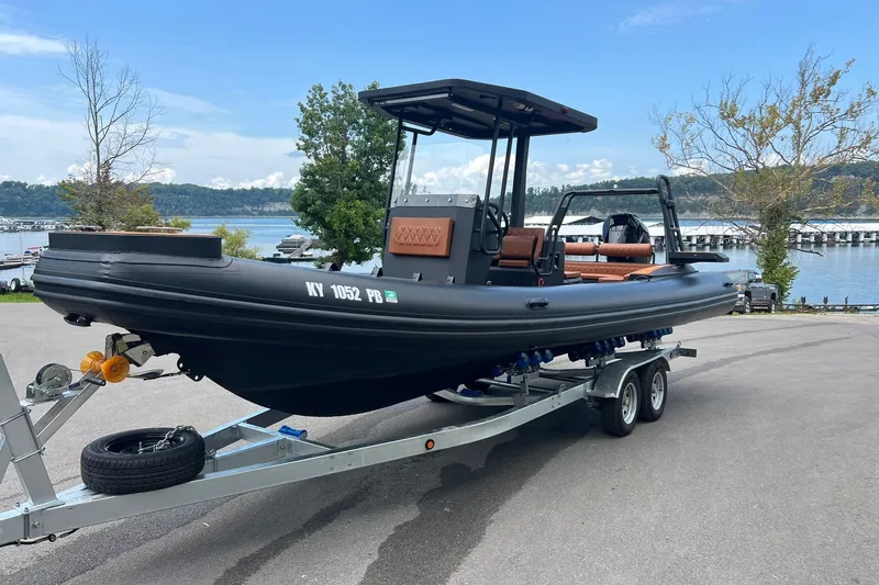 Slide: The Image of 2026 Patrol 760 RIB boat on trailer by a scenic lakeside. - 21