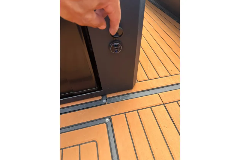 Slide: The Image of Hand operating control on 2026 Patrol 760 RIB boat's wooden deck. - 28