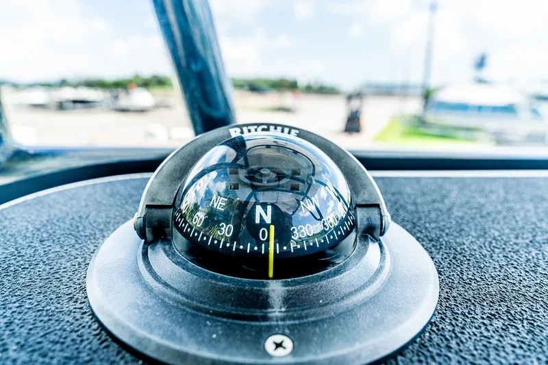 Slide: The Image of A compass on a boat points north. The background is blurred. - 14