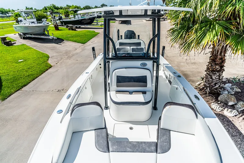 Slide: The Image of A 2019 Crevalle 24 Bay boat with spacious deck and seating, parked in a green setting. - 21