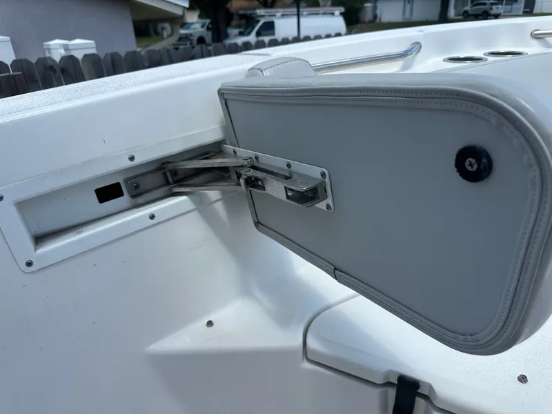 Slide: The Image of A foldable seat on a boat with white upholstery and metal bracket. - 27