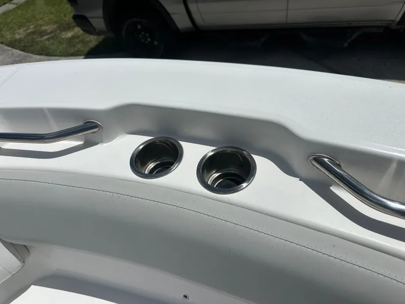 Slide: The Image of The image shows two stainless steel cup holders on a white boat, surrounded by grab rails. - 17