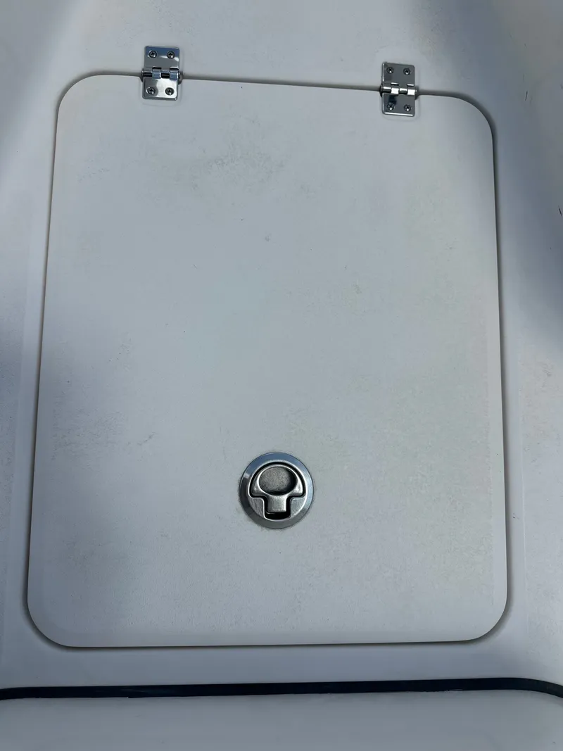 Slide: The Image of A white boat hatch with a round handle and two hinges at the top. - 21