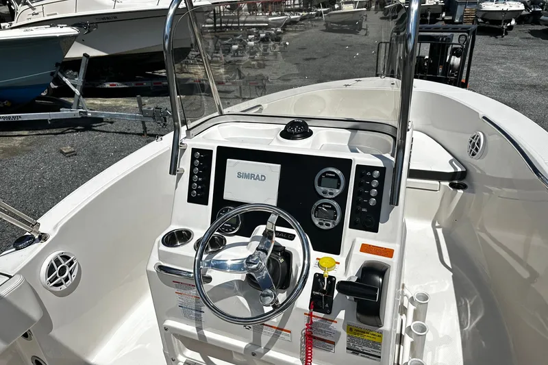 Slide: The Image of 2024 Robalo R180 Center Console boat interior with steering wheel and Simrad display. - 4
