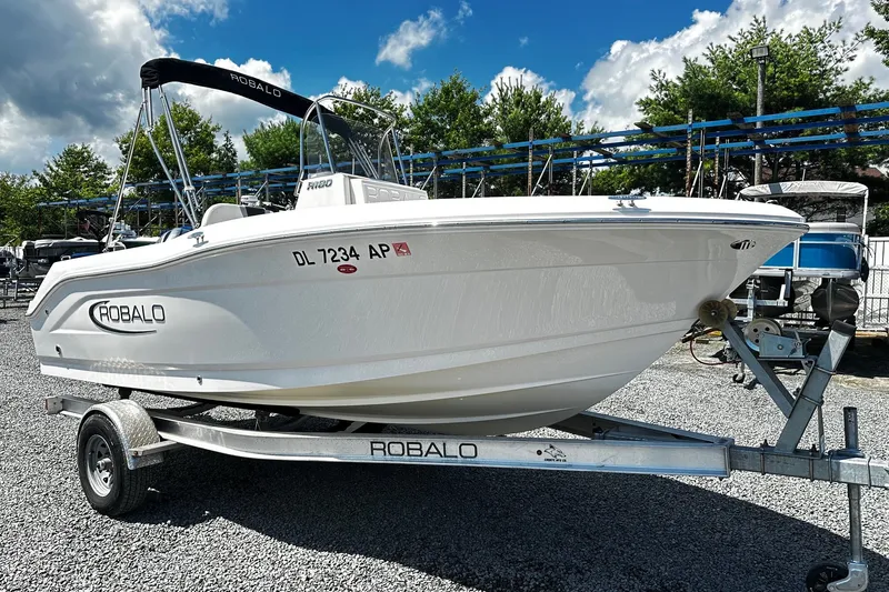 The Image of 2024 Robalo R180 Center Console boat on trailer, parked outdoors. - 0