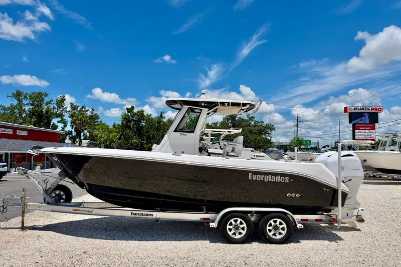 The Image of 2014 Everglades 255 Center Console boat on trailer under clear blue sky. - 0