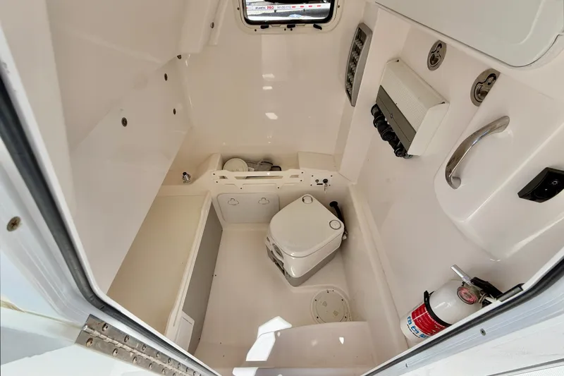 Slide: The Image of Interior of 2014 Everglades 255 Center Console boat with toilet and safety equipment. - 27