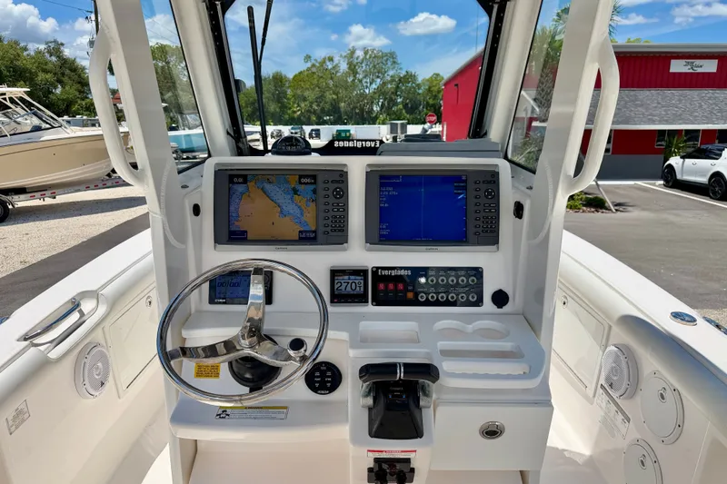 Slide: The Image of 2014 Everglades 255 Center Console boat dashboard with navigation screens and steering wheel. - 14