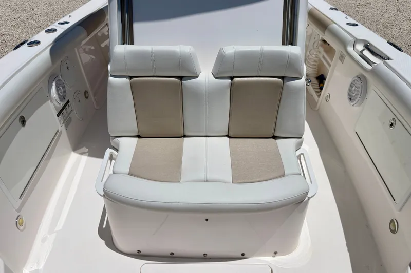 Slide: The Image of 2014 Everglades 255 Center Console boat seating area with white and beige cushions. - 11