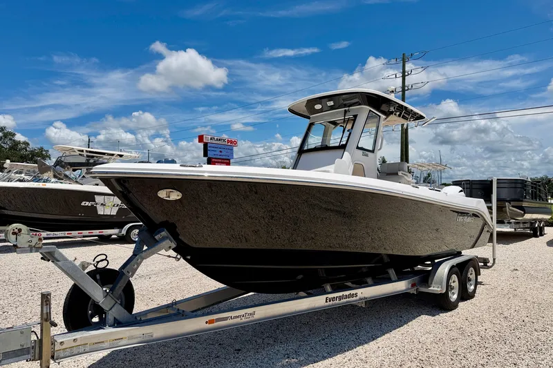 Slide: The Image of 2014 Everglades 255 Center Console boat on trailer under blue sky. - 1