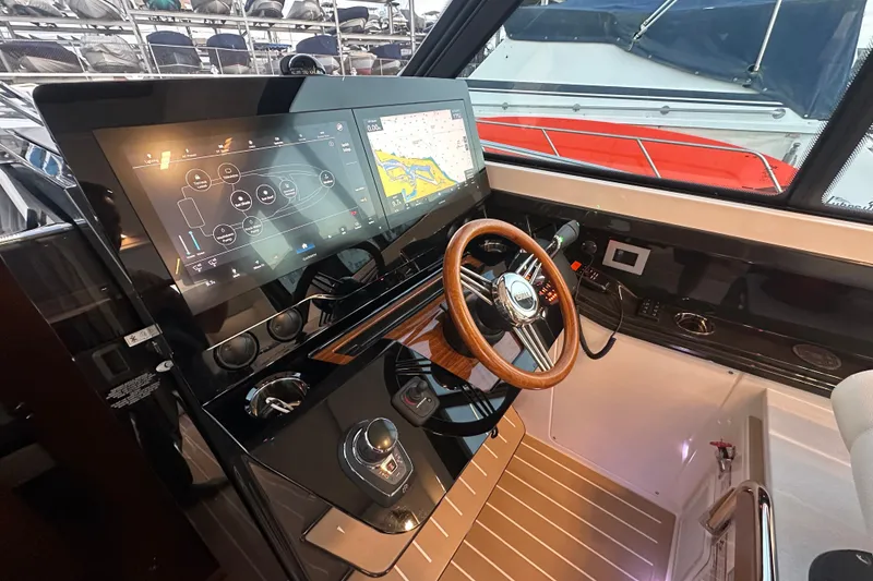 Slide: The Image of Helm of 2027 Tiara Yachts 39 LE with advanced navigation displays and wooden steering wheel. - 21