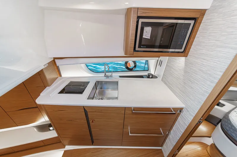 Slide: The Image of Modern galley kitchen in 2027 Tiara Yachts 39 LE, featuring sleek wood cabinetry and appliances. - 59