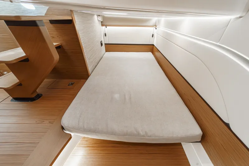 Slide: The Image of 2027 Tiara Yachts 39 LE interior cabin with wooden accents and cushioned seating. - 73