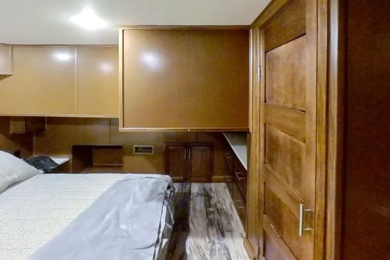 Slide: The Image of Interior of a 2016 Thoroughbred 21 x 100, featuring wooden cabinetry and a cozy bed. - 16
