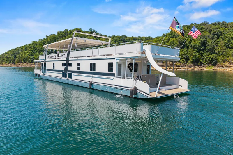 Slide: The Image of Luxurious 2016 Thoroughbred houseboat "Memory Maker" on serene lake with slide and flags. - 5