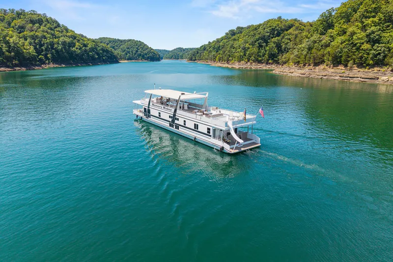 Slide: The Image of Houseboat "Memory Maker" cruising on a scenic lake, surrounded by lush green hills. - 3