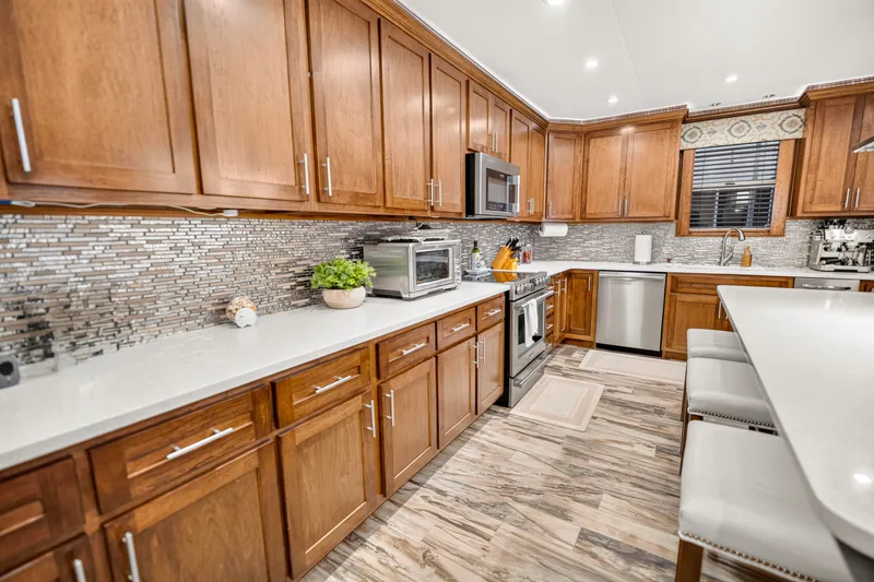 Slide: The Image of Modern kitchen with wooden cabinets, stainless steel appliances, and sleek tile backsplash, Thoroughbred 21 x 100. - 13