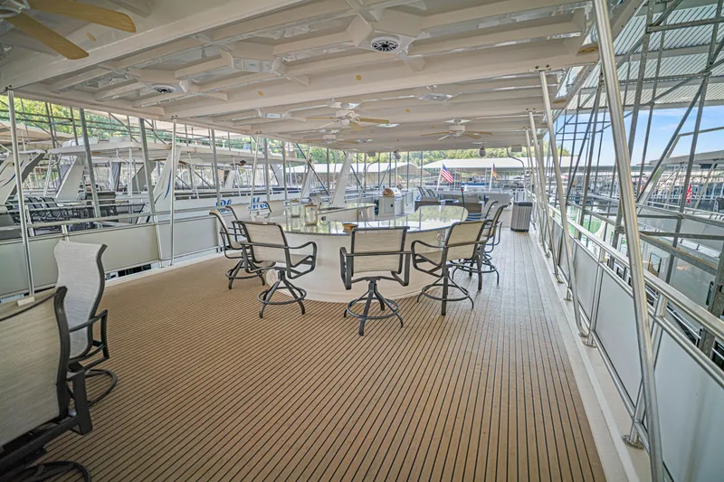 Slide: The Image of Spacious upper deck of 2016 Thoroughbred 21 x 100 houseboat with seating and ceiling fans. - 22
