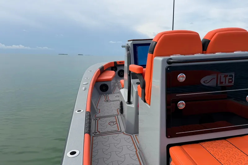 Slide: The Image of 2026 Latitude Tournament Boats 25 with orange seating, sleek design, and ocean backdrop. - 20