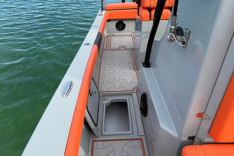 Slide: The Image of 2026 Latitude Tournament Boats 25 interior with orange accents and patterned flooring on water. - 25