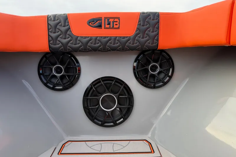 Slide: The Image of 2026 Latitude Tournament Boats 25 interior with orange and black upholstery, featuring built-in speakers. - 24
