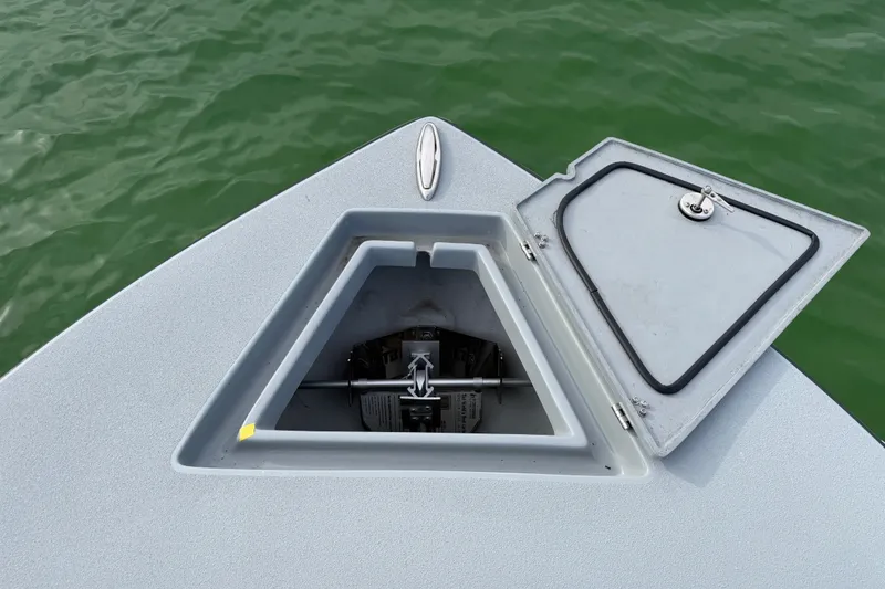 Slide: The Image of Open anchor compartment on 2026 Latitude Tournament Boats 25, with green water background. - 26