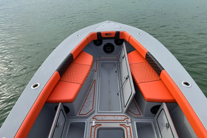 Slide: The Image of 2026 Latitude Tournament Boats 25 with orange seating and storage compartments on calm water. - 17